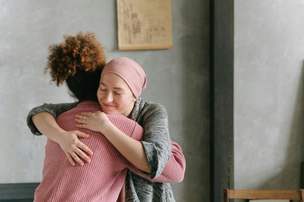 pexels-photo-7659454-7659454 Two women embracing each other with warmth and love, symbolizing support and care indoors.